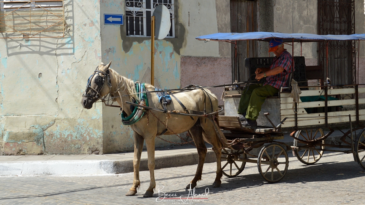 Cuban man sleeping in a horse carriage on the street in Santa Clara