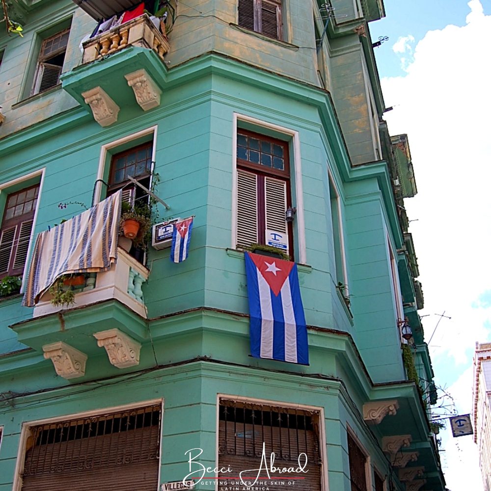 Cuban flag hanging from the window in an old colorful building in Centro Havana