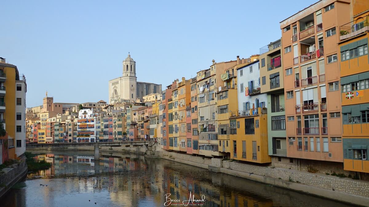 Girona Day Trip: A serene view of the Onyar River with reflections of Girona’s colorful houses