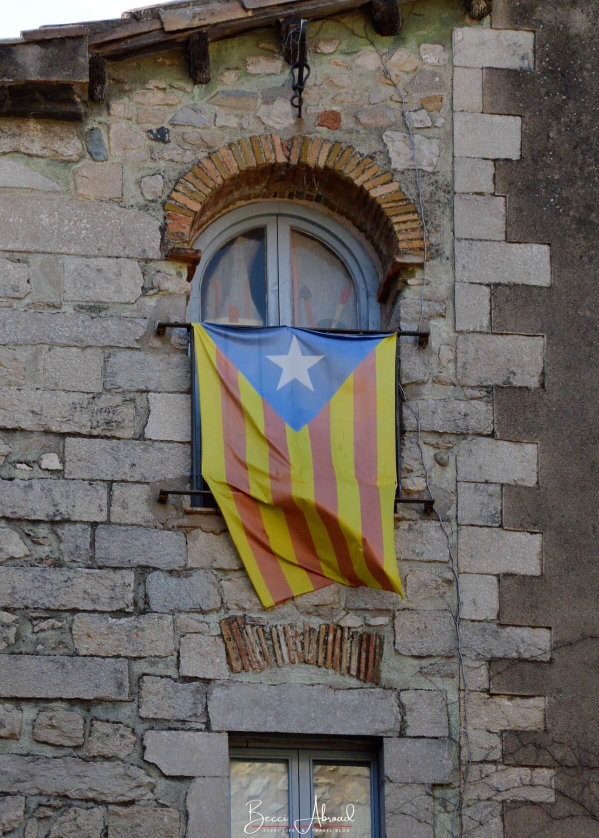 Catalan flag on stone wall in Girona, Catalonia