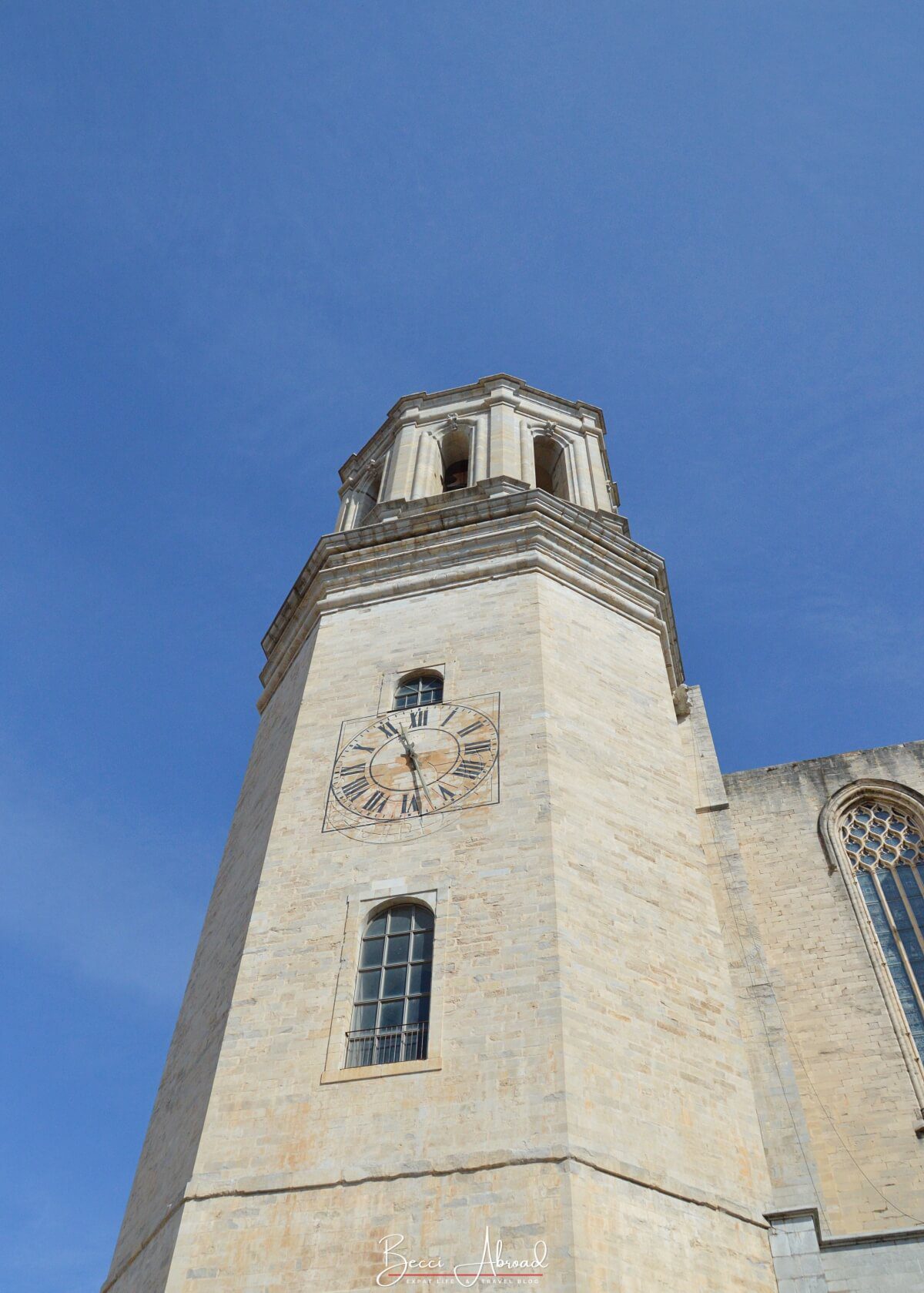 The Church of Sant Feliu's bell tower against a blue sky