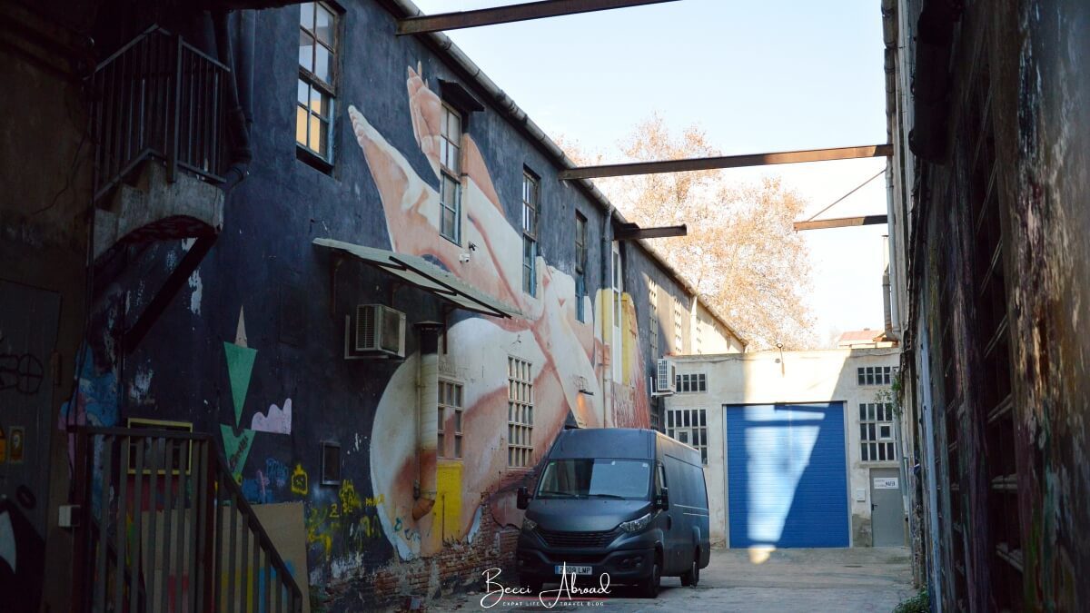 Parking lot in Poblenou Barcelona with a gigant street art mural of a person laying down