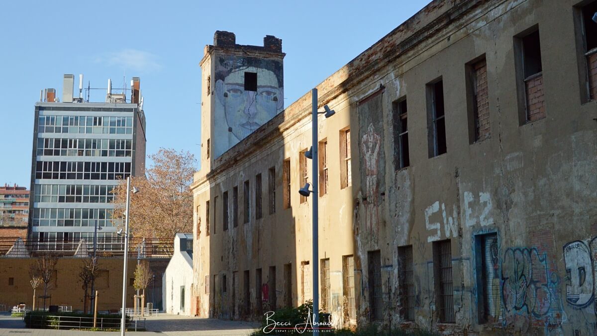 Street art mural of a big blue face on the tower in Poblenou, Barcelona