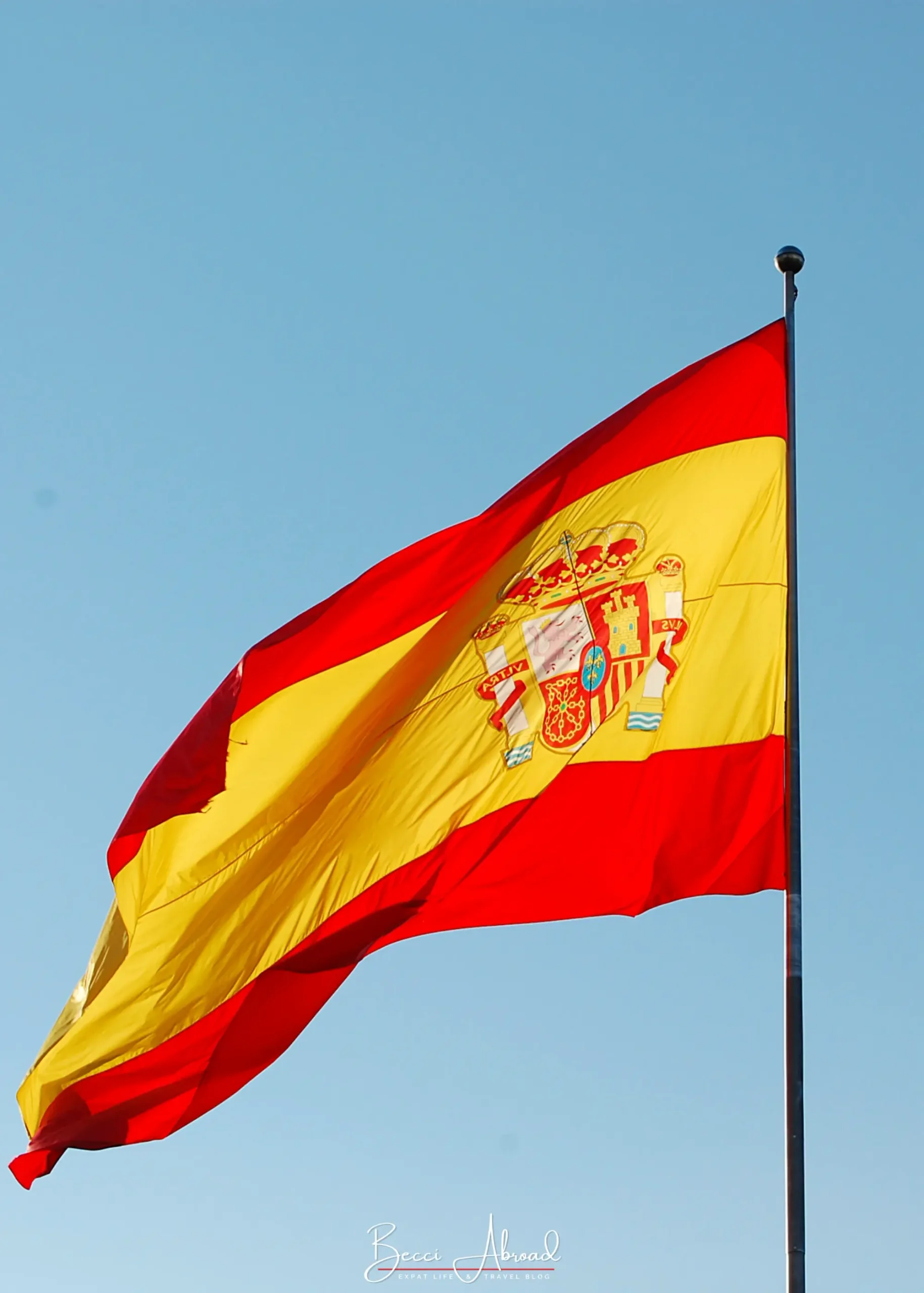 Spanish flag against a clear blue winter sky